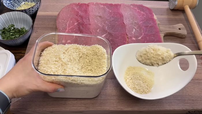 En un bol, mezclar el pan molido, el aceite de oliva, la albahaca picada, la cebolla picada, el ajo picado, el perejil picado, sal y pimienta. Agregar queso parmesano al gusto (opcional).