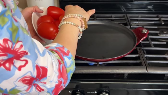 Asar los jitomates en un comal a fuego medio bajo hasta que estén blandos. Si se prefiere una preparación rápida, se pueden usar 2 latas de puré de jitomate.