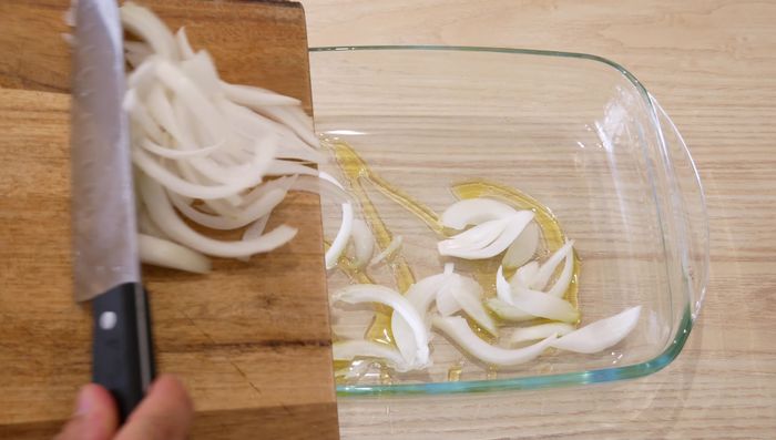 Colocar un chorrito de aceite en una bandeja para horno y añadir la cebolla.