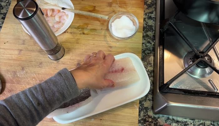 Después de 5 minutos de cocción, agregar la merluza, la pimienta al gusto y cocinar unos 6-7 minutos más.