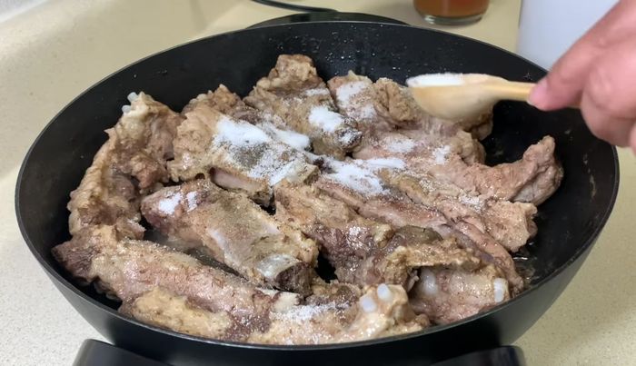 Agregar dos cucharaditas de azúcar a las costillas doradas y mover para que se caramelicen. [153.44]