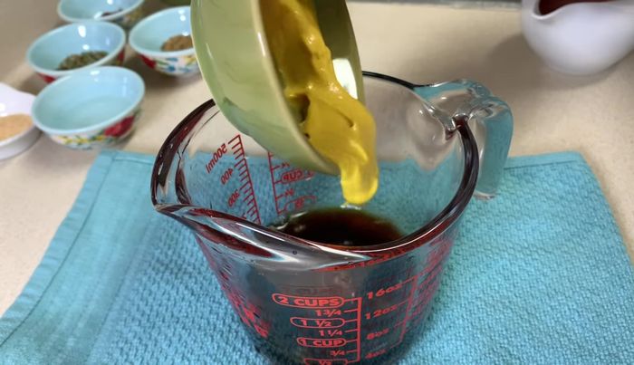Mientras se cocinan las costillas, preparar el adobo: mezclar la salsa de soya, el zumo de limón, la mostaza, la salsa de tomate, el vinagre, las especias (cebolla en polvo, ajo en polvo, comino, orégano, pimentón), sal, pimienta y el agua. [87.799]