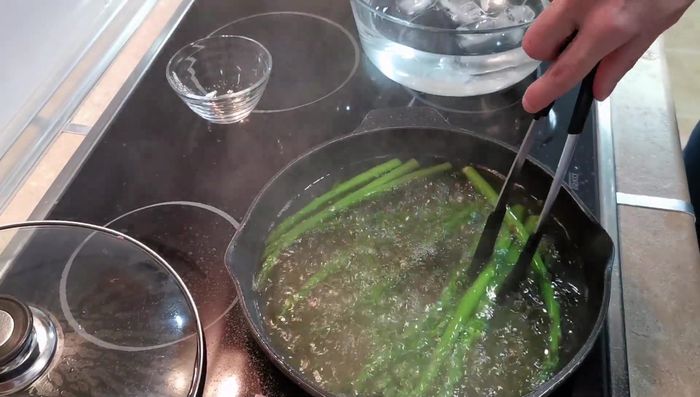 Sacar los espárragos del agua hirviendo y sumergirlos en el agua con hielo durante 3 minutos.