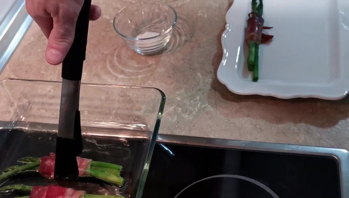Servir los espárragos con jamón y un huevo de codorniz encima de cada uno.