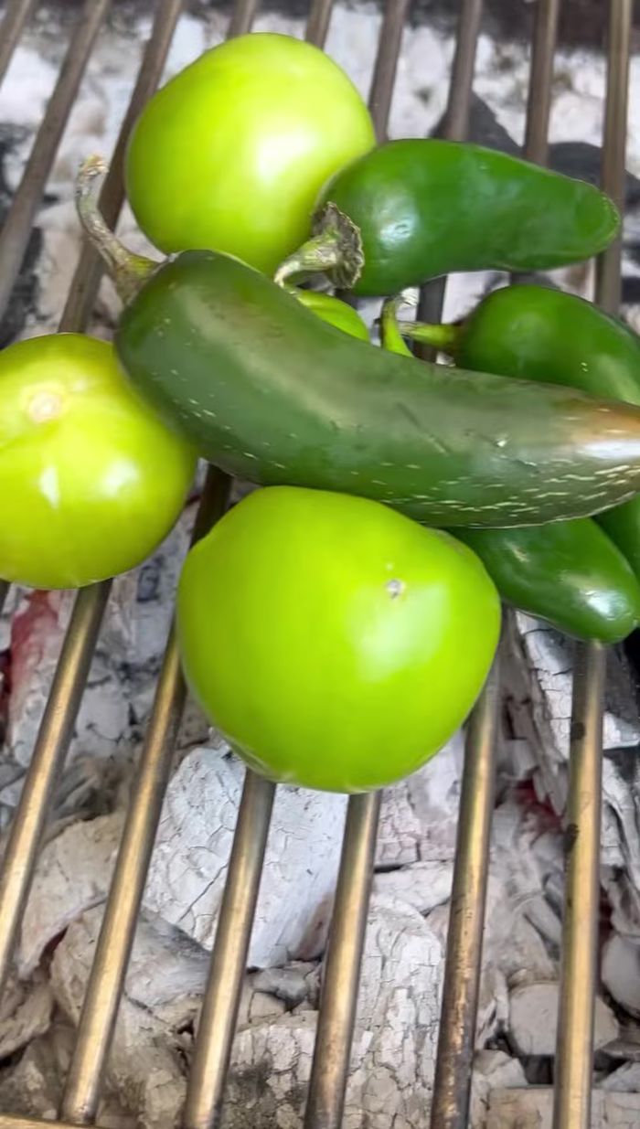 Mientras hierven los machitos, prepara la salsa verde: tatema los tomates y chiles jalapeños.
