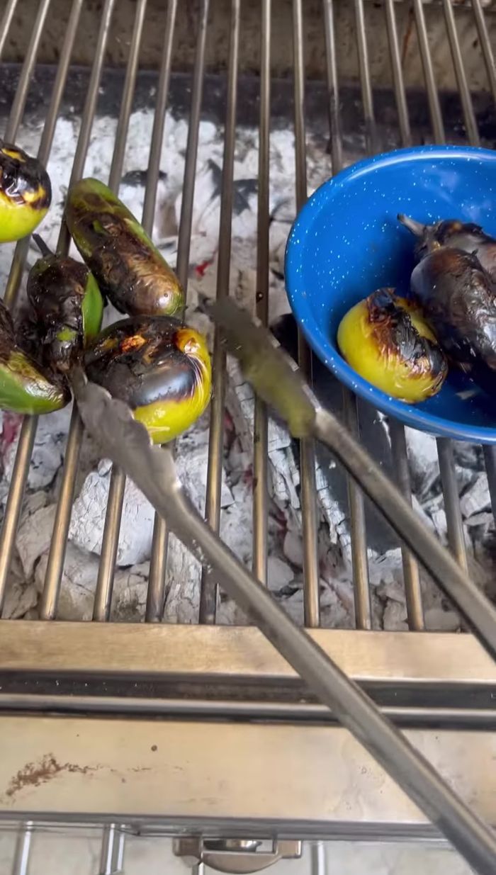 En un molcajete, muele el ajo, los chiles jalapeños tatemados y los tomates. Sazona con sazonador.