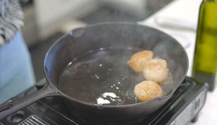 Colocar las vieiras en la sartén caliente y cocinar durante aproximadamente 2 minutos por lado, hasta que se doren y se puedan voltear fácilmente.