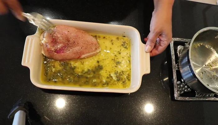Colocar las pechugas de pollo en el recipiente con la salsa, con la piel hacia abajo. (221.59)