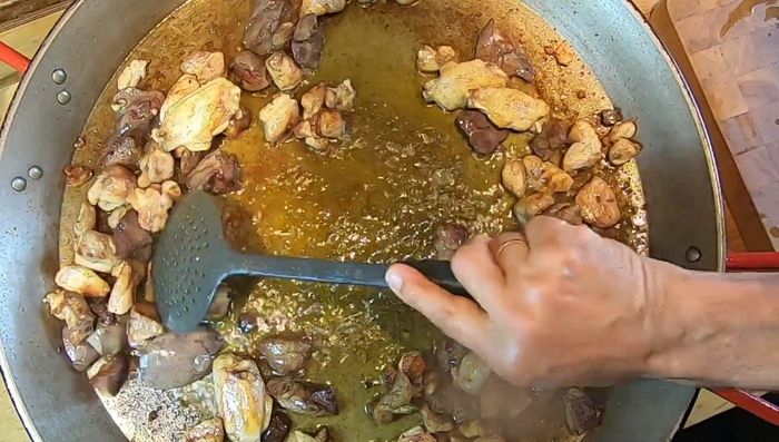 Hacer un hueco en el centro y agregar el tomate rallado para comenzar el sofrito.