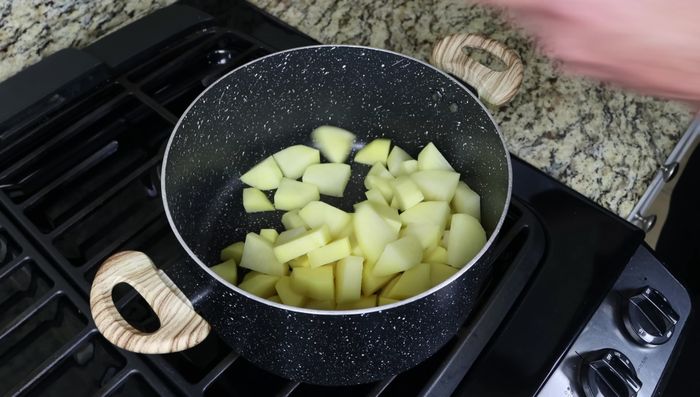 Añadir las patatas a una olla, cubrirlas con agua y sazonar generosamente con sal marina. Cocer a fuego alto hasta que estén al dente (unos 15 minutos).