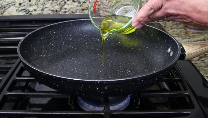 Calentar el aceite de oliva en una sartén grande a fuego medio. Agregar la cebolla, los pimientos y el ajo. Sofreír durante 5 minutos.