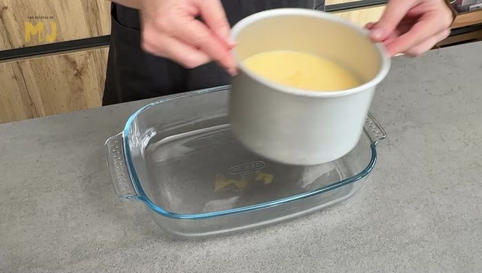 Colocar el molde en una bandeja apta para horno. Verter agua caliente hasta la mitad del molde.
