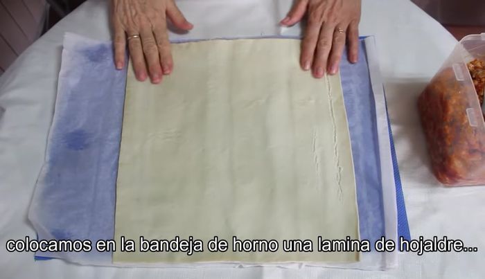 Extiende una lámina de hojaldre en una bandeja de horno. Coloca la carne en el centro, sin llegar a los bordes.