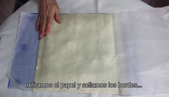 Cubre con la otra lámina de hojaldre. Retira el papel y sella los bordes con un tenedor.