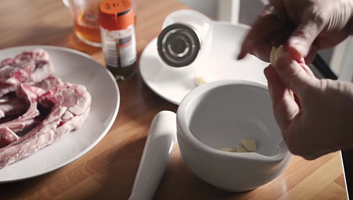 Preparar el majado: En un mortero, machacar los dientes de ajo con un poco de sal gorda y comino molido.