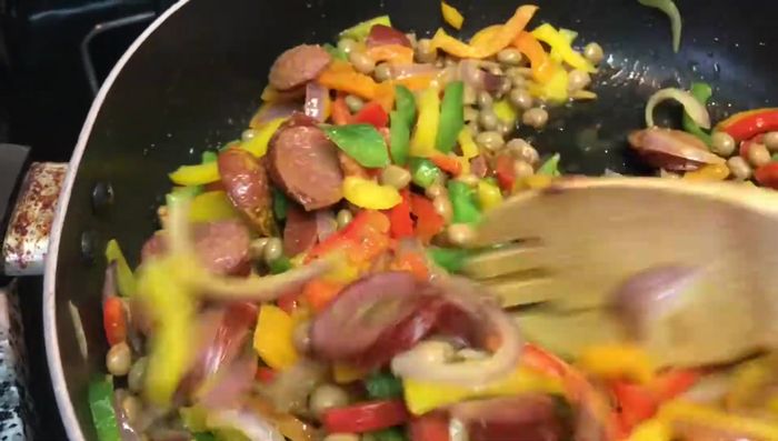 Agregar el arroz cocido a la sartén con el chorizo, pimientos, cebolla y huevo.