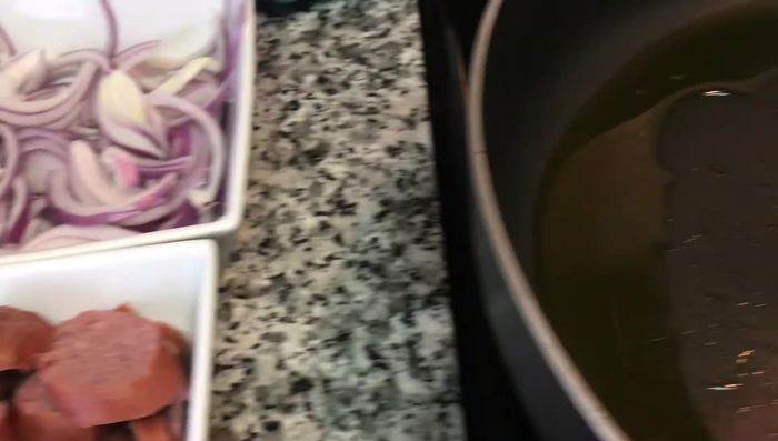 Calentar aceite de oliva en una sartén. Agregar la cebolla y el chorizo (o salchichas).