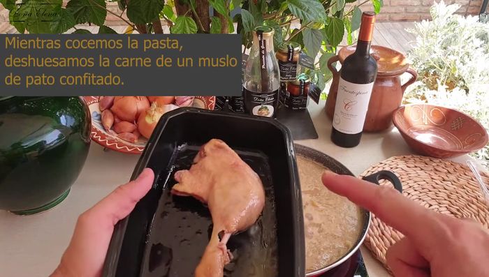 Mientras la pasta se cuece, deshuesa el confit de pato y trocea la carne. Reserva la grasa del confit.