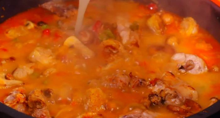 Añadir el arroz, las carnes y la butifarra reservadas. Mezclar suavemente.