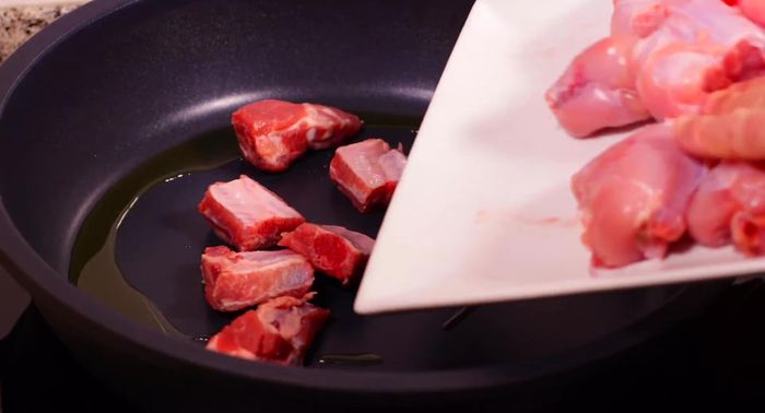 En una paellera con un chorrito de aceite caliente, sellar todas las carnes (costilla, conejo y pollo) durante 2 minutos por cada lado. Retirar y reservar.