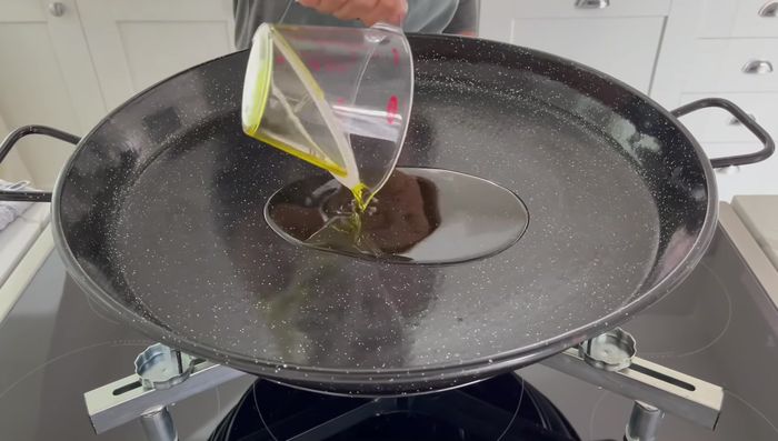 Añadir aceite a la paella.
