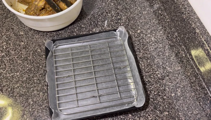 Colocar las costillas en una rejilla sobre una bandeja con papel de cocina para evitar que se sequen.