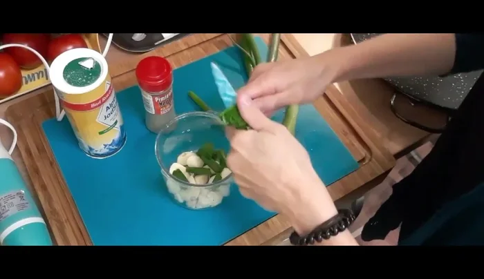 Prepara la marinada: Pica finamente los dientes de ajo y los tallos verdes de la cebolleta. En un recipiente, mezcla el ajo, la cebolleta picada, sal, pimienta, un chorrito de vino blanco y aceite de oliva. Muele todo hasta obtener una pasta homogénea.