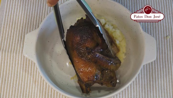 Servir el pato dorado con el puré de papas, brócoli y orégano fresco como decoración (330.27).