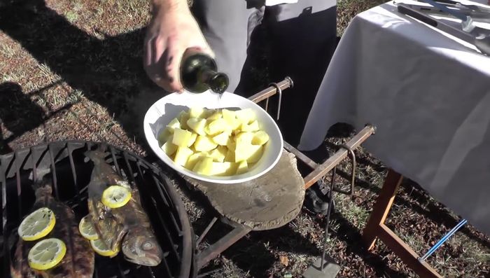 Preparar la presentación: Mezclar aceite y pimentón dulce. Agregar las papas y los pescados.