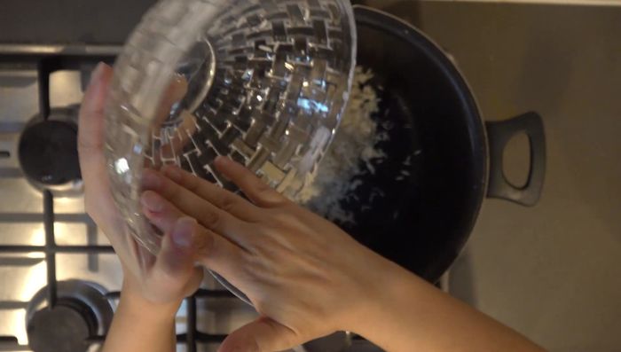 Poner el arroz lavado en una olla y agregar 9 tazas de agua. Revolver bien. [132.72]
