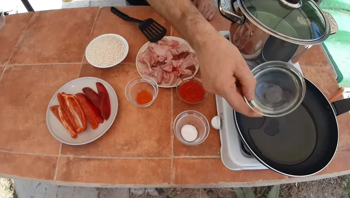 Calentar la paellera y añadir aceite. Sofreír los pimientos hasta que estén dorados.