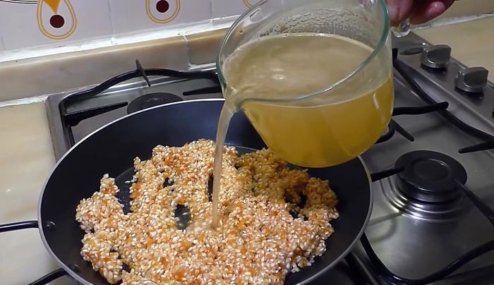 Añadir el caldo caliente a la paellera.