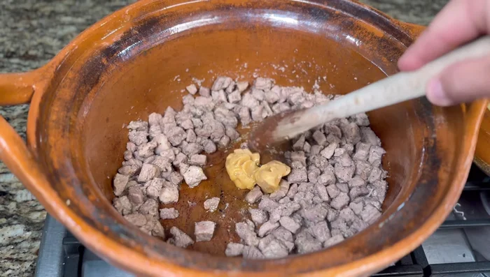 Agregar la cebolla cortada en medias lunas y dorar junto con la carne (10-15 minutos). [303.32]