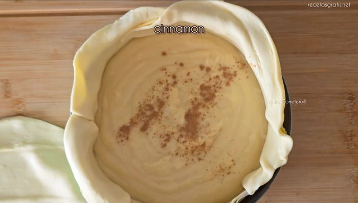 Cubre con otra plancha de hojaldre, ciérralo bien, pinta con huevo batido y decora con almendras.