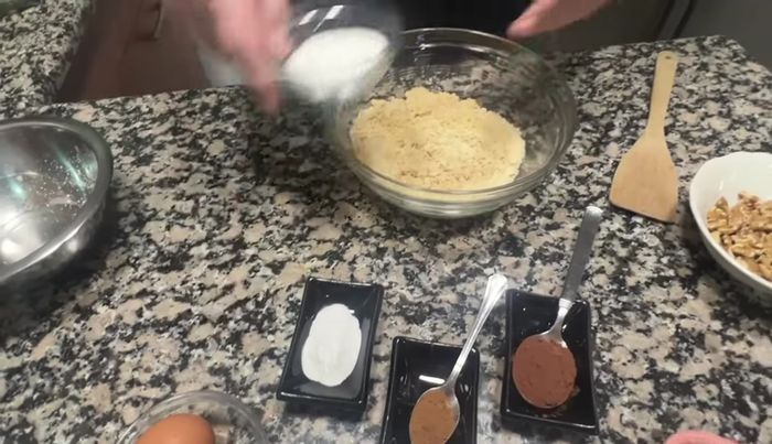 En un bol, mezclar los ingredientes secos: almendra molida, polvo de almendra, azúcar, levadura royal, cacao en polvo y canela.