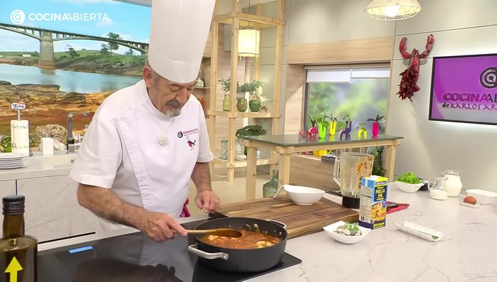 Agregar el caldo de paella, suficiente para cubrir el arroz con un poco más.