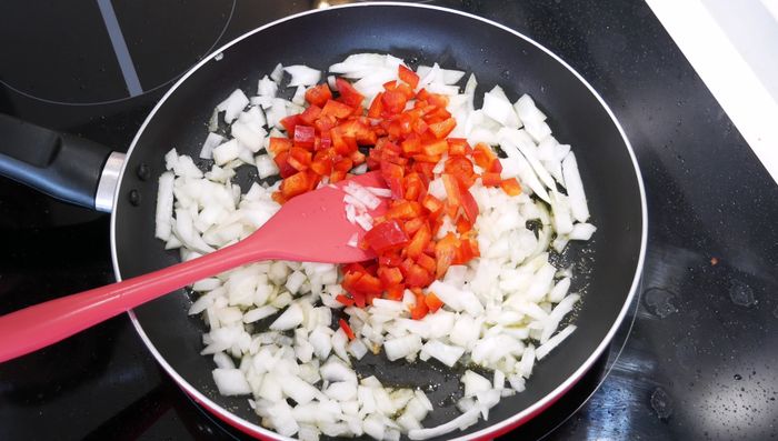 Incorporar el pimiento rojo picado y sal al gusto. Mezclar y cocinar hasta que esté todo blando. (74.32)