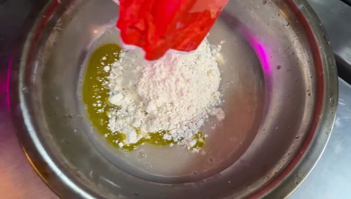 Añadir aceite de oliva y sal a la masa (la sal no debe tocar la levadura). Amasar hasta obtener una masa homogénea.