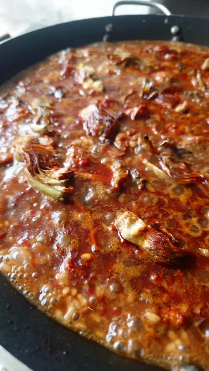 Añadir las alcachofas fritas a media cocción.