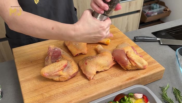 Salpimentamos un pollo cortado en cuartos por ambas caras.