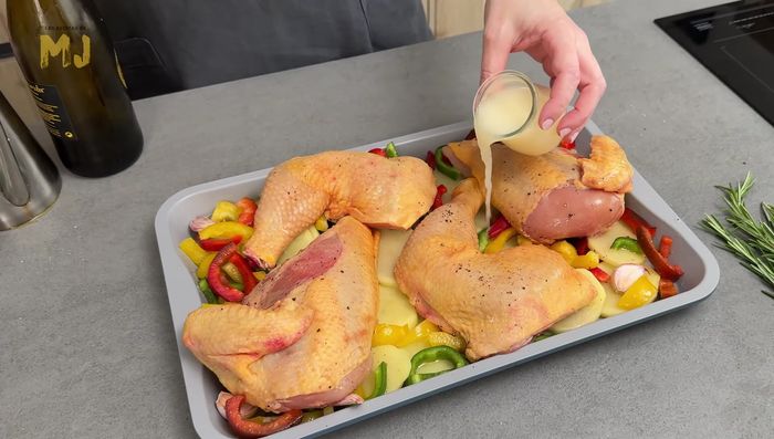 Vertemos 50 ml de vino blanco, 50 ml de caldo de pollo, un chorrito de aceite por encima de la cara sin aceite y unas ramitas de romero fresco.