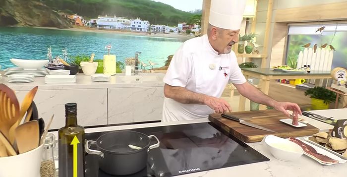 Preparamos el caldo: En una olla con agua hirviendo, añadimos la cebolleta cortada en cuatro, el hueso de jamón, dos dientes de ajo y cuatro setas. Dejamos hervir un rato (53.52).