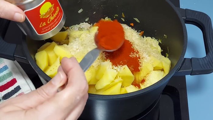 Incorporar una cucharada generosa de pimentón dulce de la Vera y remover para integrar los sabores. Agregar un pimiento seco (opcional).