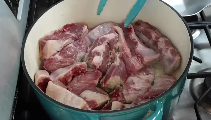En una olla amplia a fuego medio-alto, agregar un chorrito de aceite y las costillas de puerco. Saltear hasta que doren, aproximadamente 35 minutos. Agregar sal durante el proceso.