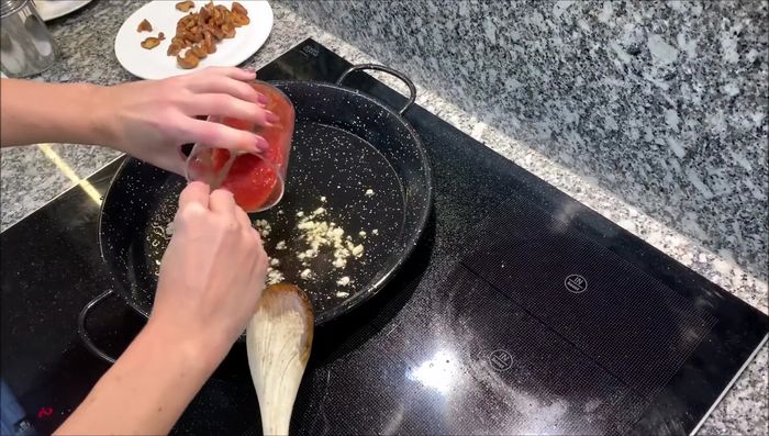 Añadir el tomate triturado y concentrado. Remover.