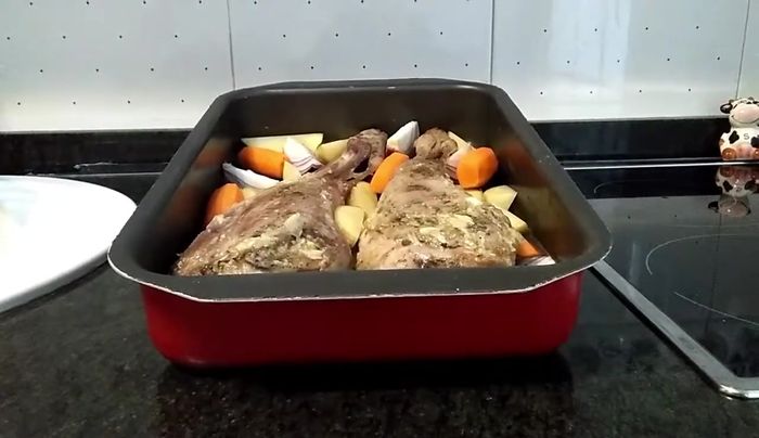 Añada las patatas, zanahorias y cebolla morada como guarnición alrededor de las piernas.