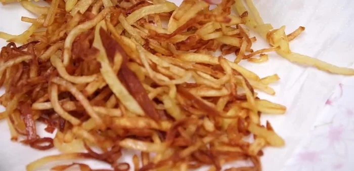 Servir la langosta Thermidor con las patatas paja.