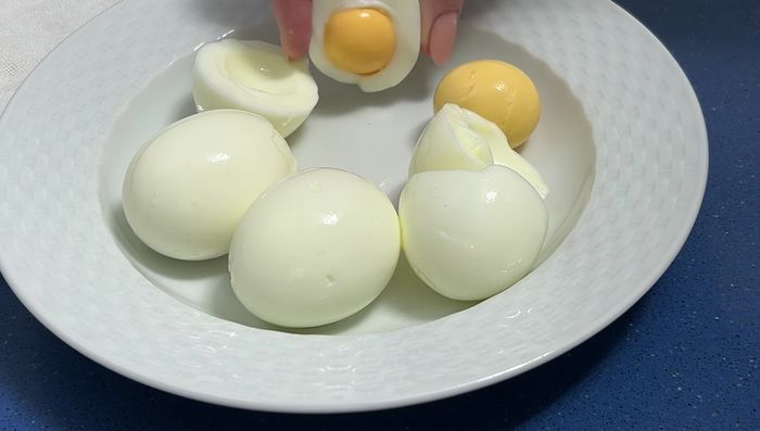 Pelar los huevos cocidos, reservar dos yemas para decorar. Triturar el resto de los huevos con un tenedor.