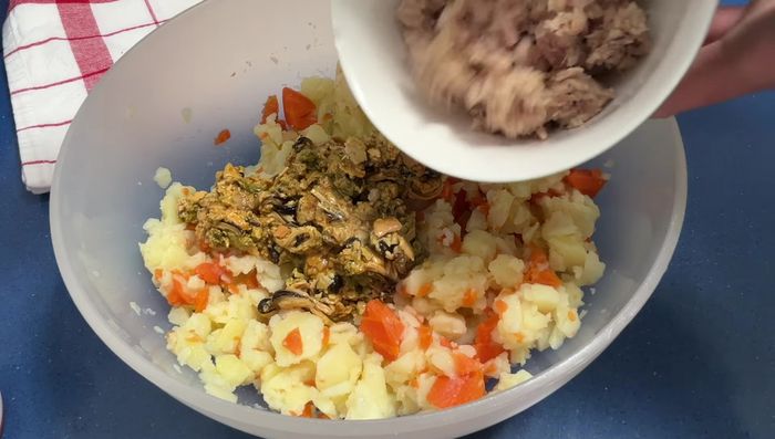 Agregar los mejillones picados, el atún escurrido y sal a las patatas y zanahorias. Mezclar bien.