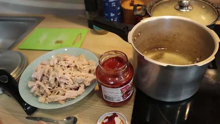 Agregar la carne de cerdo deshebrada junto con el puré de tomate, comino y pimienta negra.